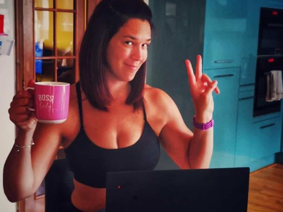 Jessica Lester holding a pink much giving a peace sign baby sos IVF workout