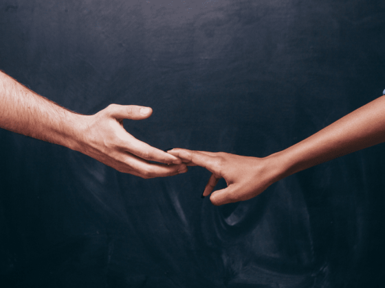 white mand hand almost letting go of a black womans hand illustrating IVF fails