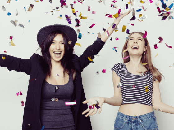 two women celebratying with glitter strands falling from the sky would you do surrogacy for your best friend